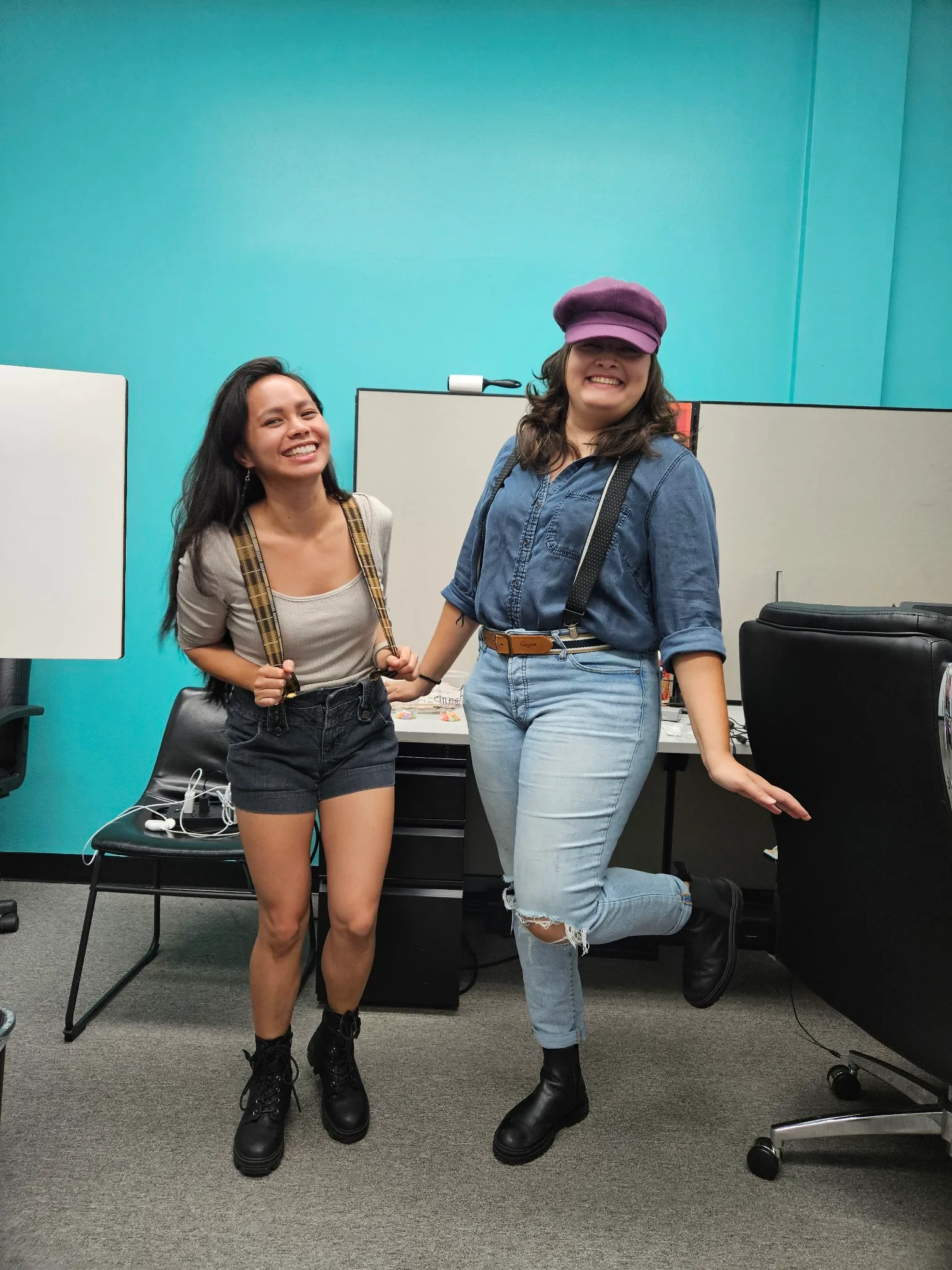 Angelika and a LunaFit teammate laughing in the office, whiteboards on a teal wall behind them.